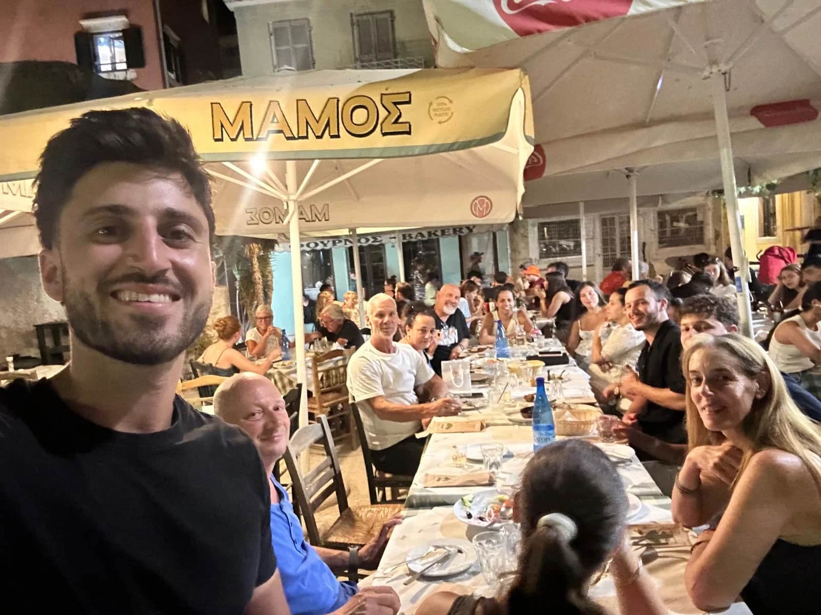 זוג מטיילים מתכנן תקציב חופשה על רקע נמל העיר קורפו